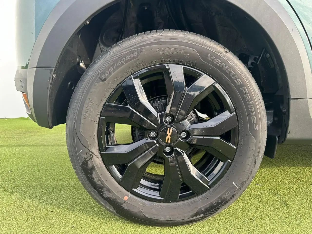 Gros plan sur la jante noire brillante 16 pouces du côté avant droit d'une Dacia Sandero Stepway vert cèdre.