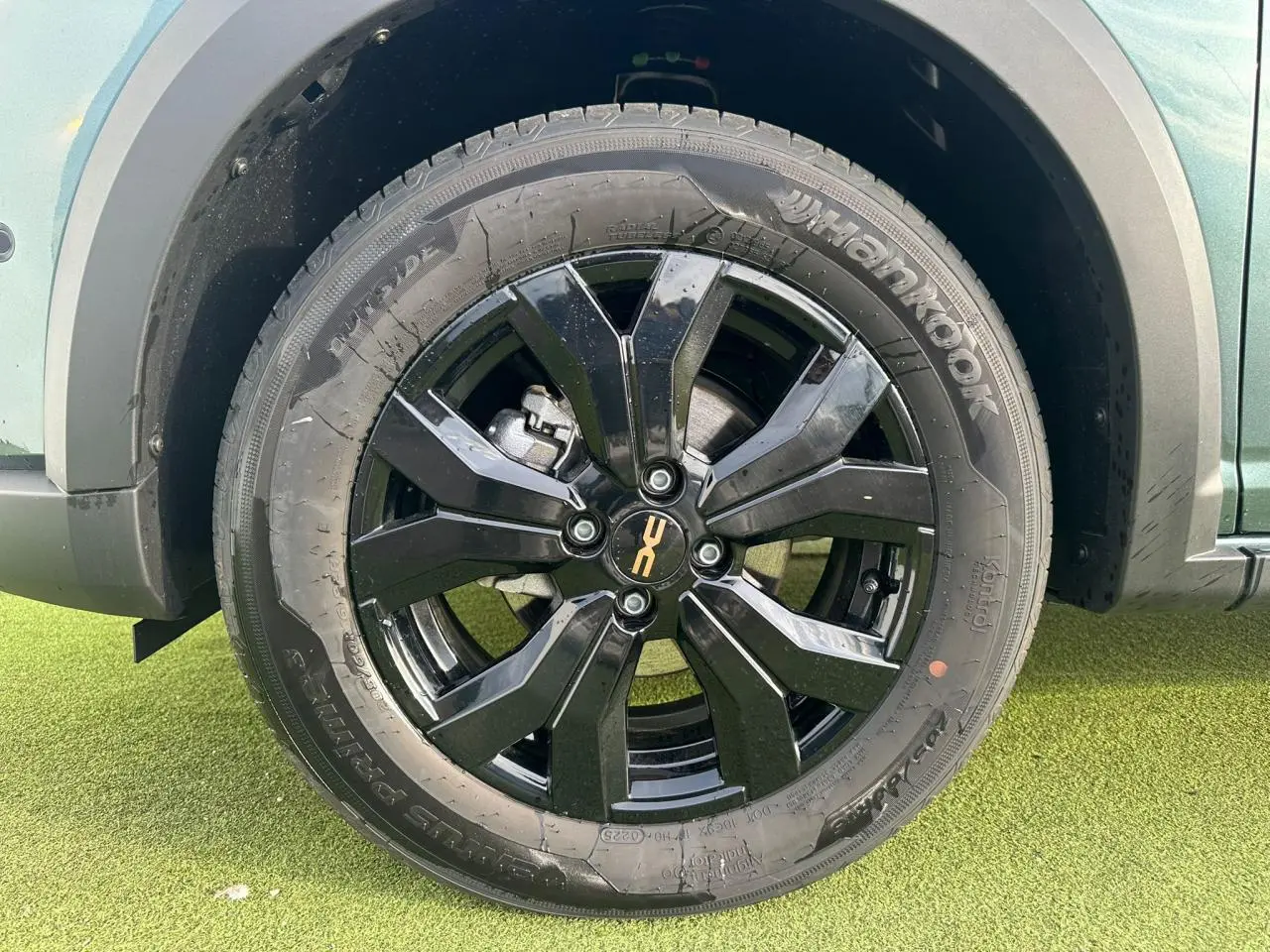 Gros plan sur la roue avant gauche noire brillante d'une Dacia Sandero Stepway 2025 vert cèdre avec jante alu 16 pouces.