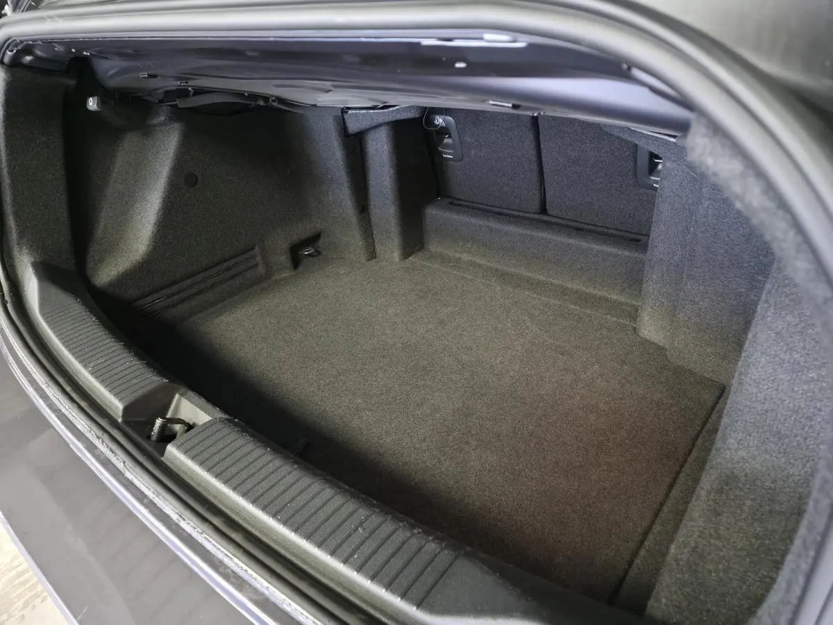 Coffre ouvert vu de dessus du Volkswagen T-Roc Cabriolet gris 2024, montrant l'espace de rangement intérieur.