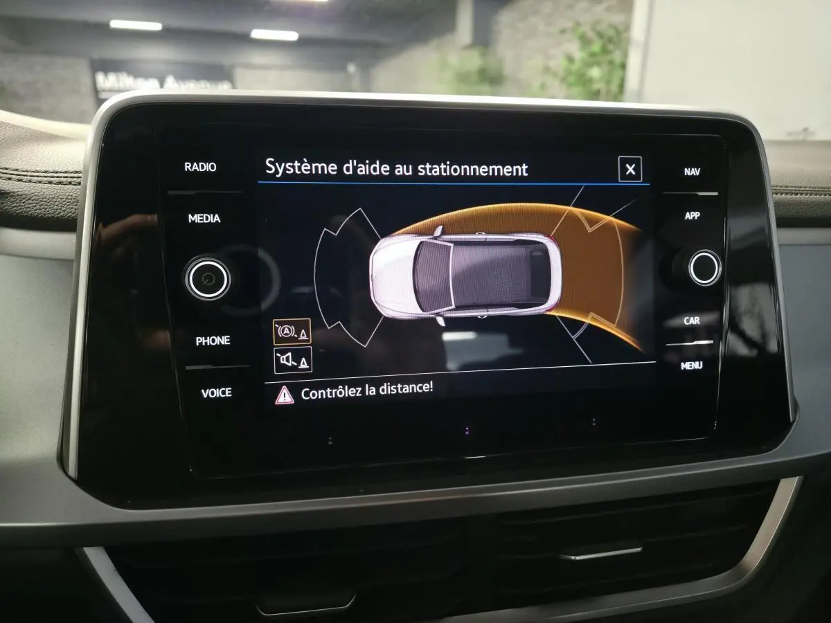 Écran tactile du système d'aide au stationnement dans un Volkswagen T-Roc Cabriolet gris, vue intérieure centrale.