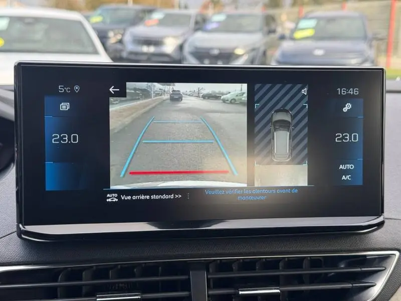 Écran intérieur du Peugeot 3008 2024 montrant la caméra de recul avec lignes de guidage et vue 360° du véhicule noir.