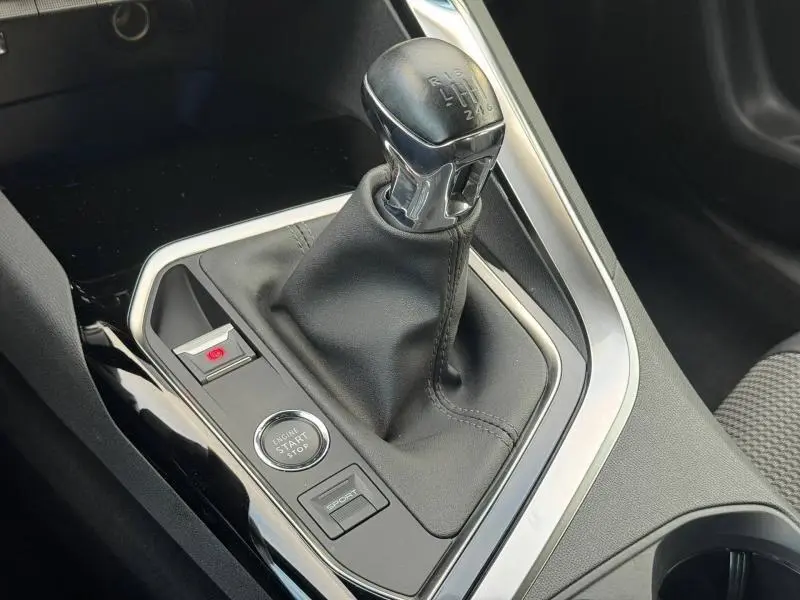 Gros plan sur le levier de vitesse manuel et la console centrale du Peugeot 3008 noir 2024, avec bouton start/stop et mode sport.