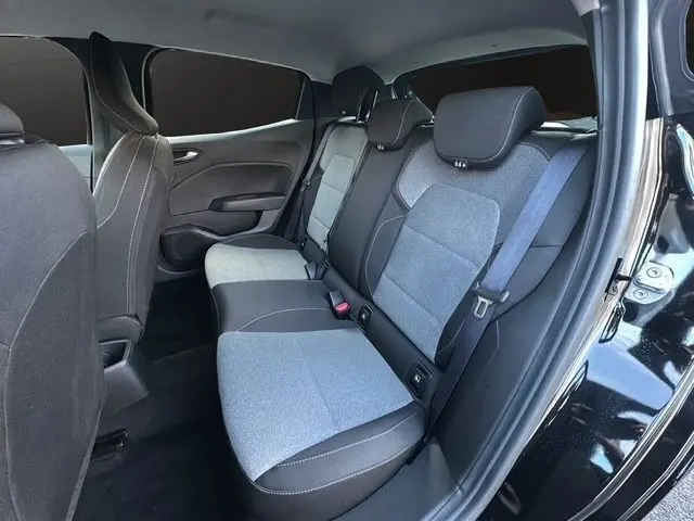 Vue intérieure arrière côté droit de la Renault Clio noire 2025, montrant la banquette 3 places bicolore avec ceintures de sécurité.