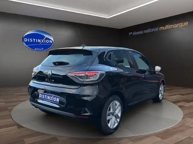 Vue 3/4 arrière droite d'une Renault Clio noire 2025 avec feux LED et jantes alliage visibles en showroom.