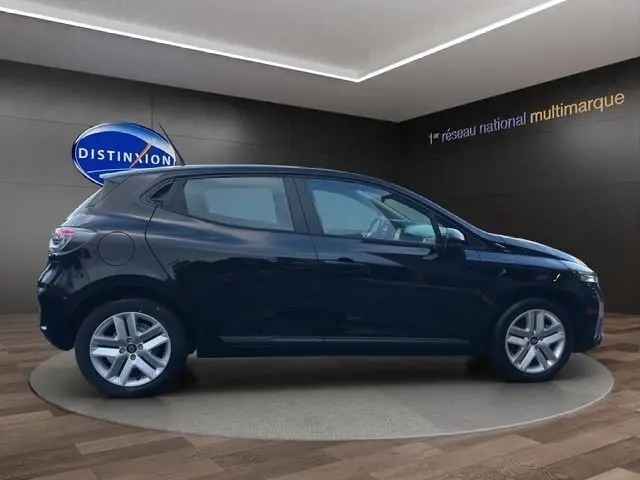 Profil droit d'une Renault Clio noire 2025 dans un showroom, mettant en valeur ses lignes épurées et jantes alliage.