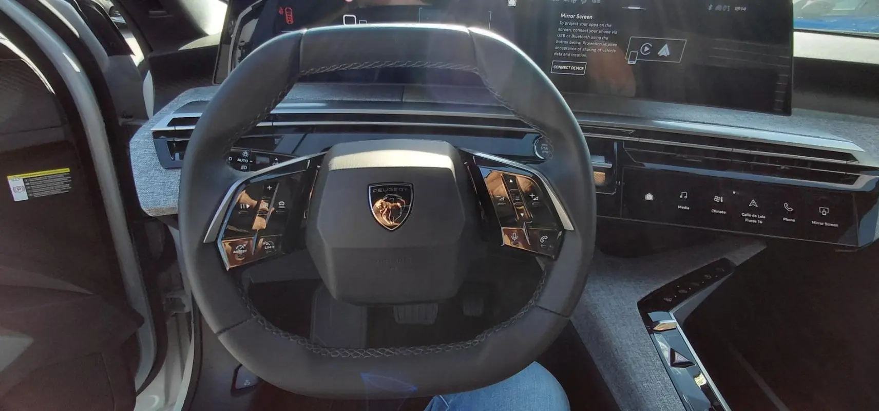 Vue intérieure centrée sur le volant du Peugeot 5008 blanc 2025, avec tableau de bord numérique et finitions modernes.