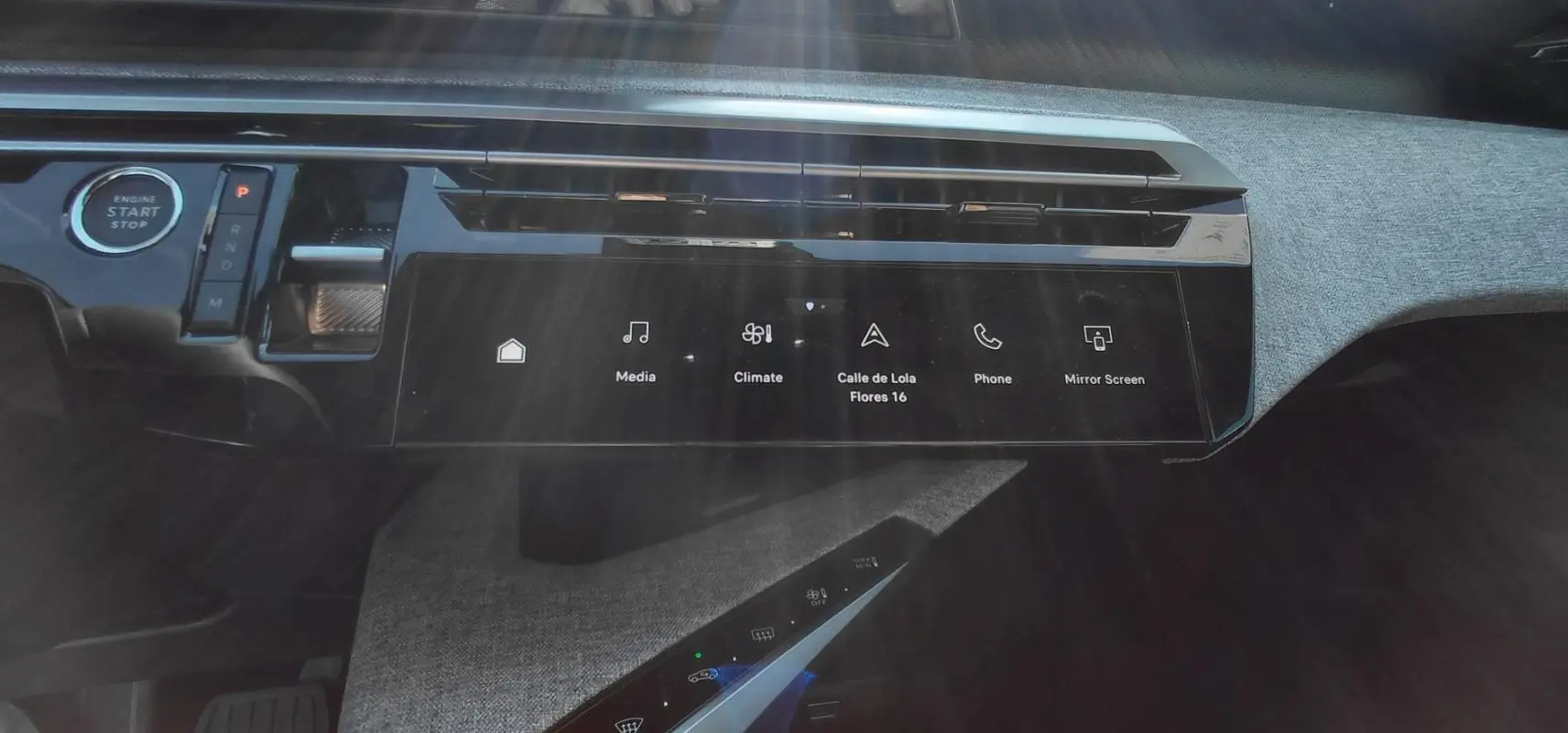 Vue rapprochée du tableau de bord du Peugeot 5008 Hybrid 2025, mettant en valeur l'écran tactile et la molette de boîte automatique.