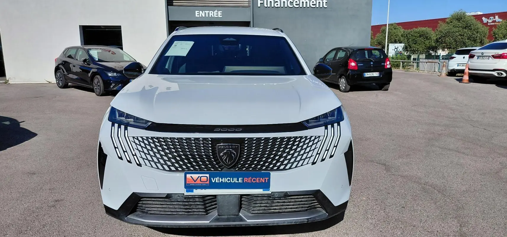 Vue frontale d’un Peugeot 5008 blanc 2025 avec calandre moderne et feux LED verticaux distinctifs.