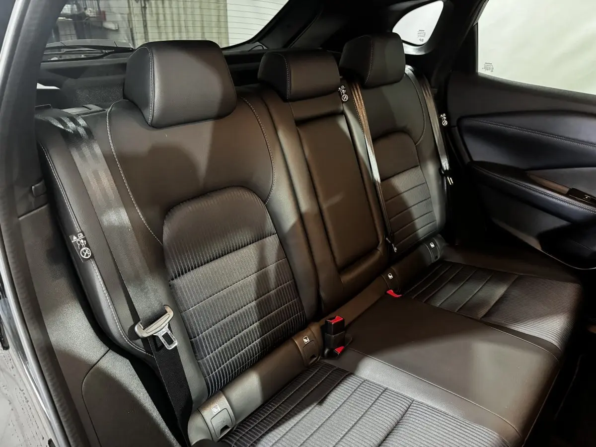 Vue intérieure du siège arrière noir en cuir du Nissan Qashqai e-Power 190 Tekna BVA 2023, avec ceintures de sécurité visibles.