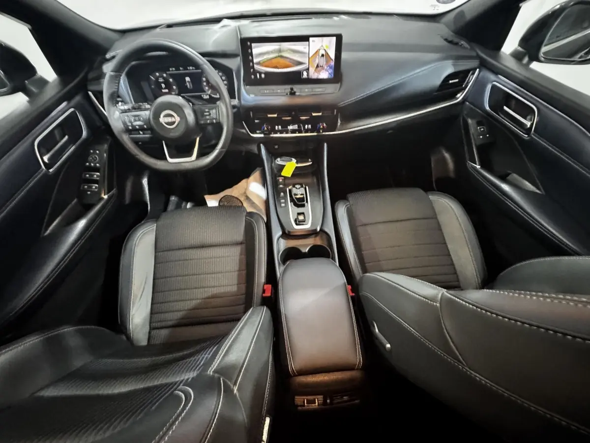 Intérieur noir du Nissan Qashqai e-Power 190 Tekna 2023 vu de dessus, avec tableau de bord digital et écran tactile central.