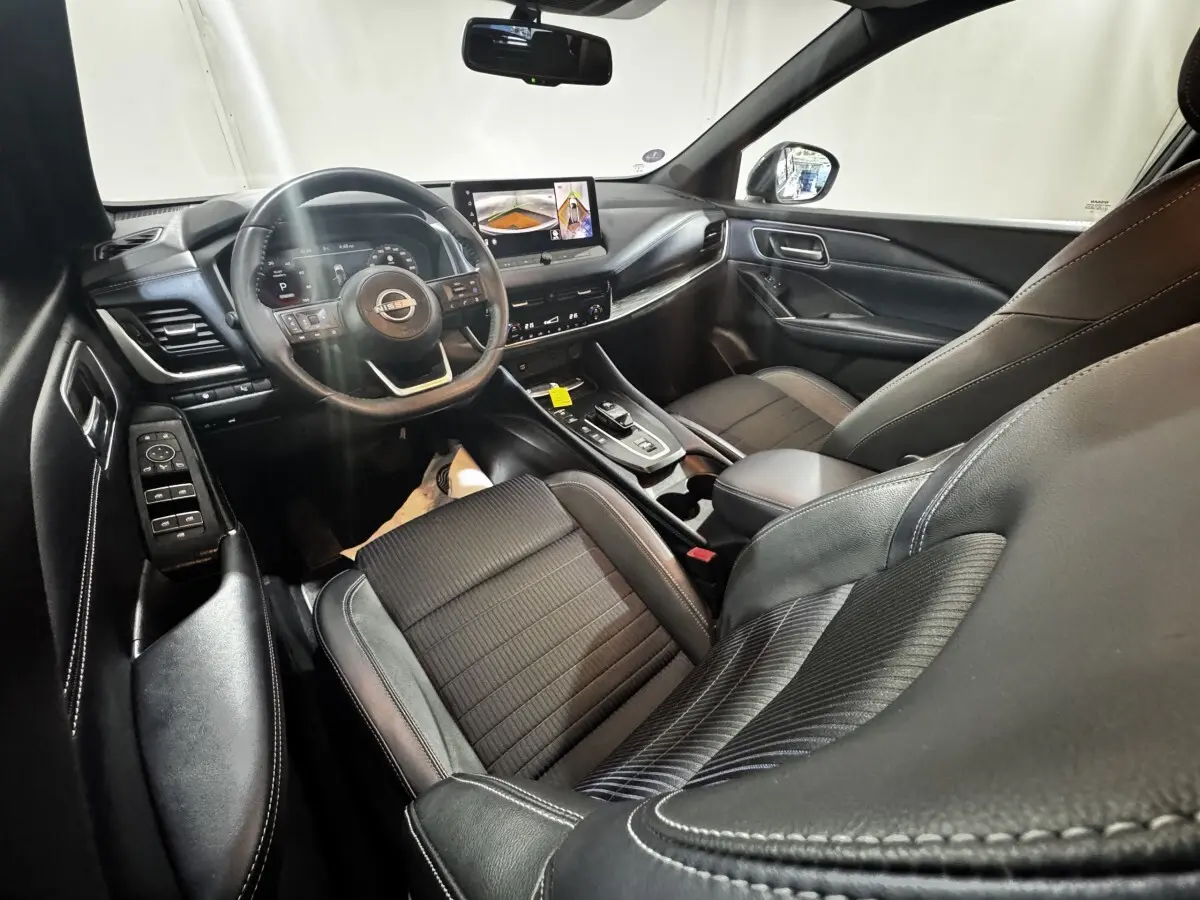 Intérieur noir du Nissan Qashqai e-Power 190 Tekna 2023, vue côté conducteur avec tableau de bord et écran tactile.