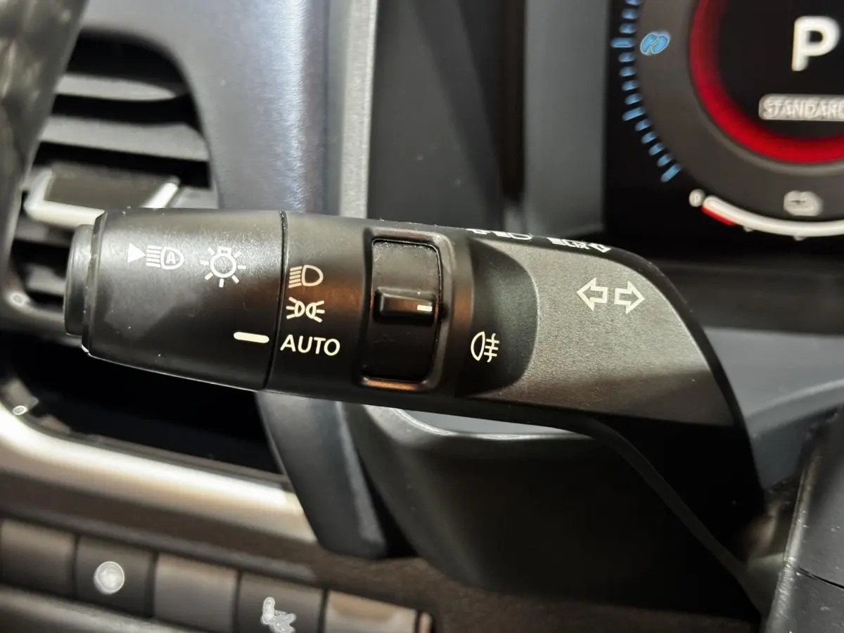 Gros plan sur la commande des phares et clignotants côté gauche du tableau de bord du Nissan Qashqai e-Power noir 2023.