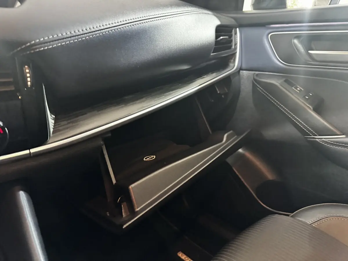 Intérieur noir du Nissan Qashqai e-Power 2023, vue côté passager avec boîte à gants ouverte et finitions cuir.