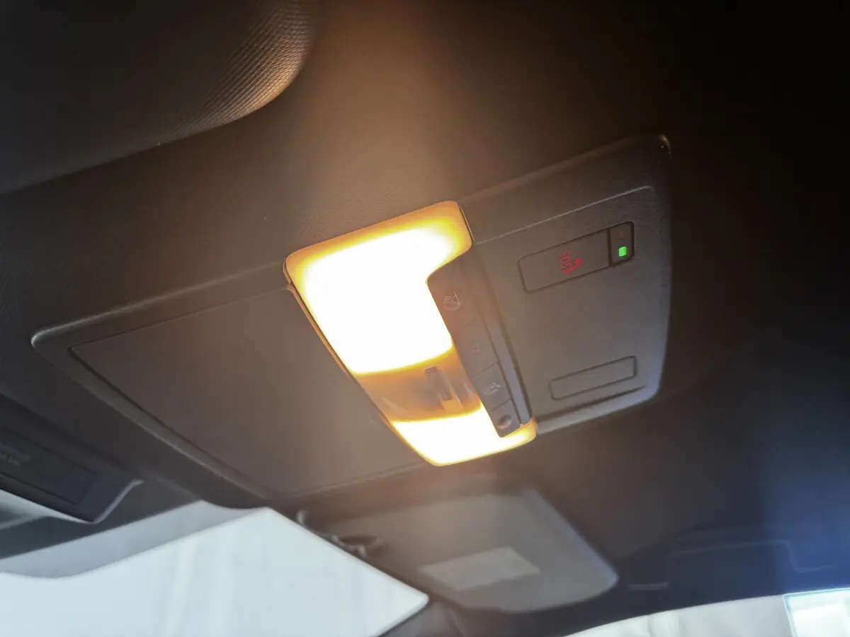 Plafonnier intérieur allumé avec commandes SOS et éclairage ambiant dans un Nissan Qashqai e-Power noir 2023.
