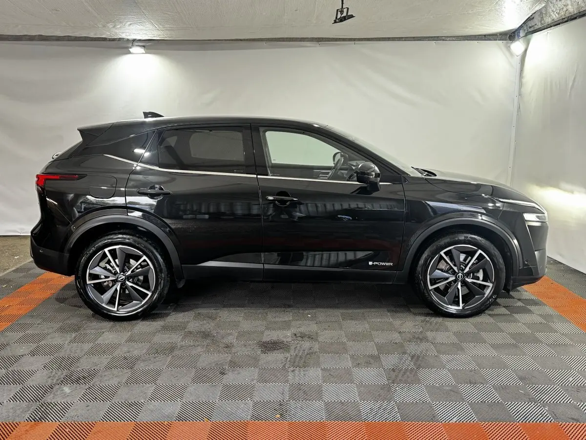 Vue de profil côté gauche du Nissan Qashqai e-Power 190 Tekna BVA noir avec jantes alliage et badge e-Power visible.