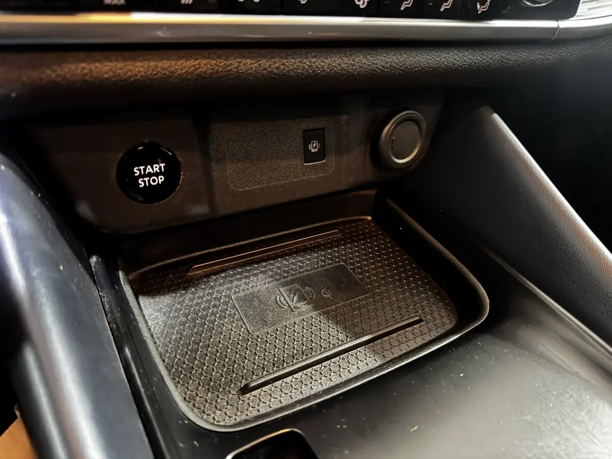 Gros plan sur la zone de recharge sans fil et bouton Start/Stop du Nissan Qashqai e-Power noir, intérieur avant.