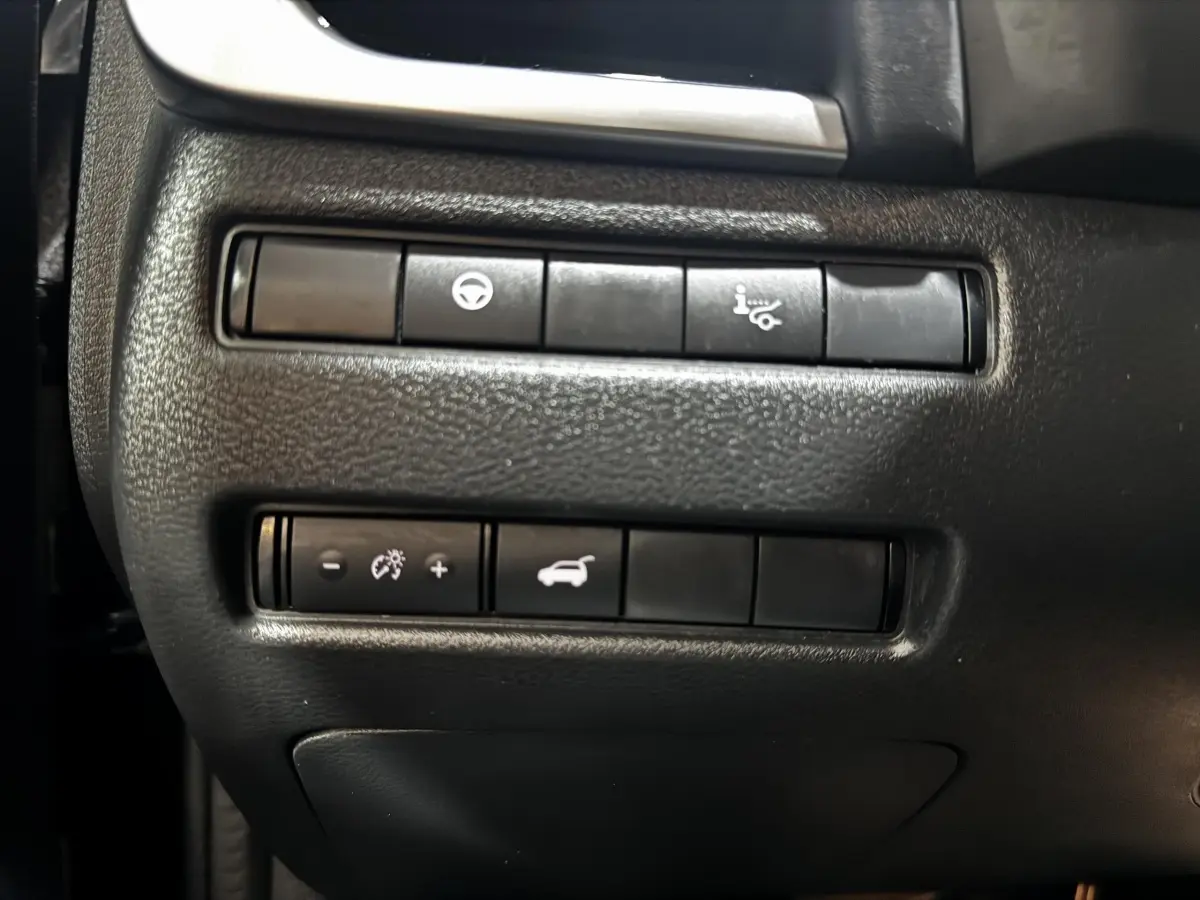 Gros plan sur les commandes de tableau de bord noir du Nissan Qashqai e-Power 190 Tekna BVA 2023, boutons fonctionnels visibles.