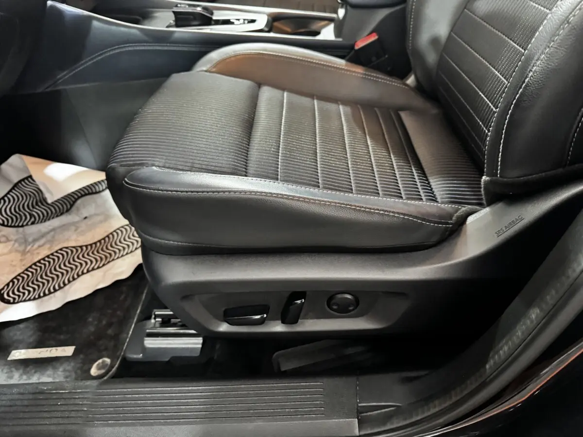 Gros plan sur le siège avant droit noir en cuir et tissu du Nissan Qashqai e-Power 2023 avec commandes électriques.