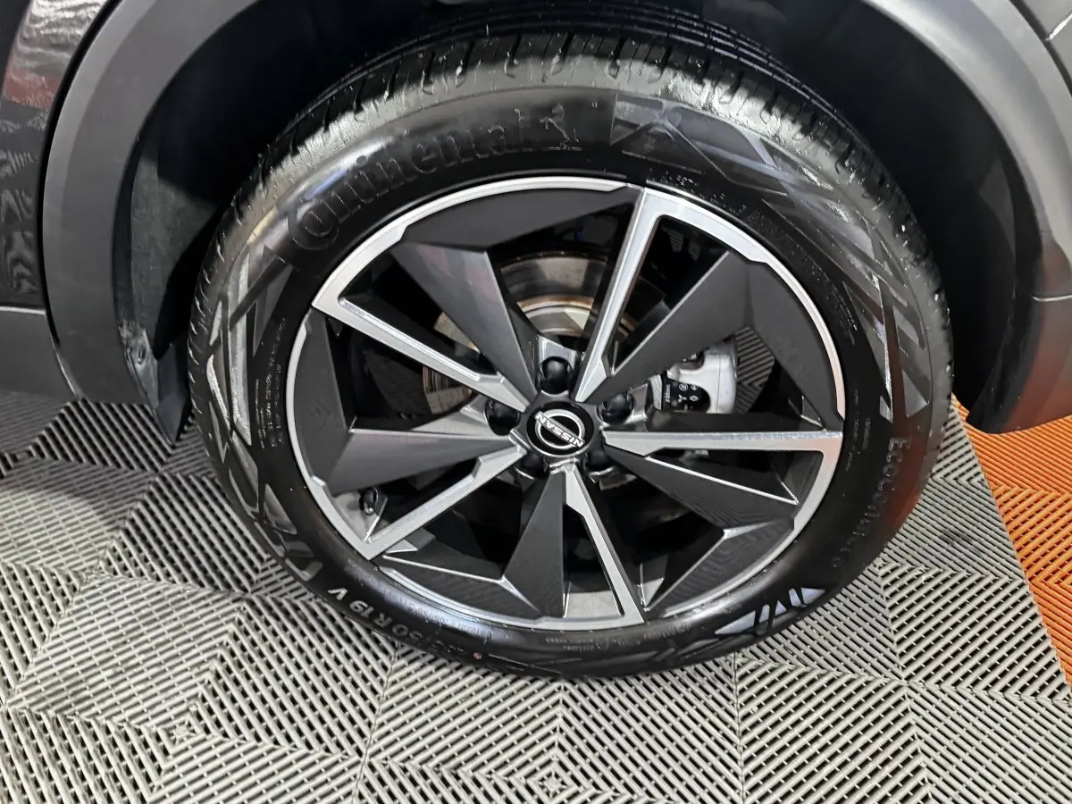 Gros plan sur la roue avant droite du Nissan Qashqai e-Power 190 Tekna BVA noir, jante alliage bicolore moderne.
