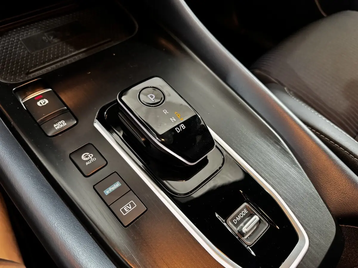 Gros plan sur la console centrale noire du Nissan Qashqai e-Power 190 Tekna 2023 avec sélecteur de boîte auto et boutons de mode.