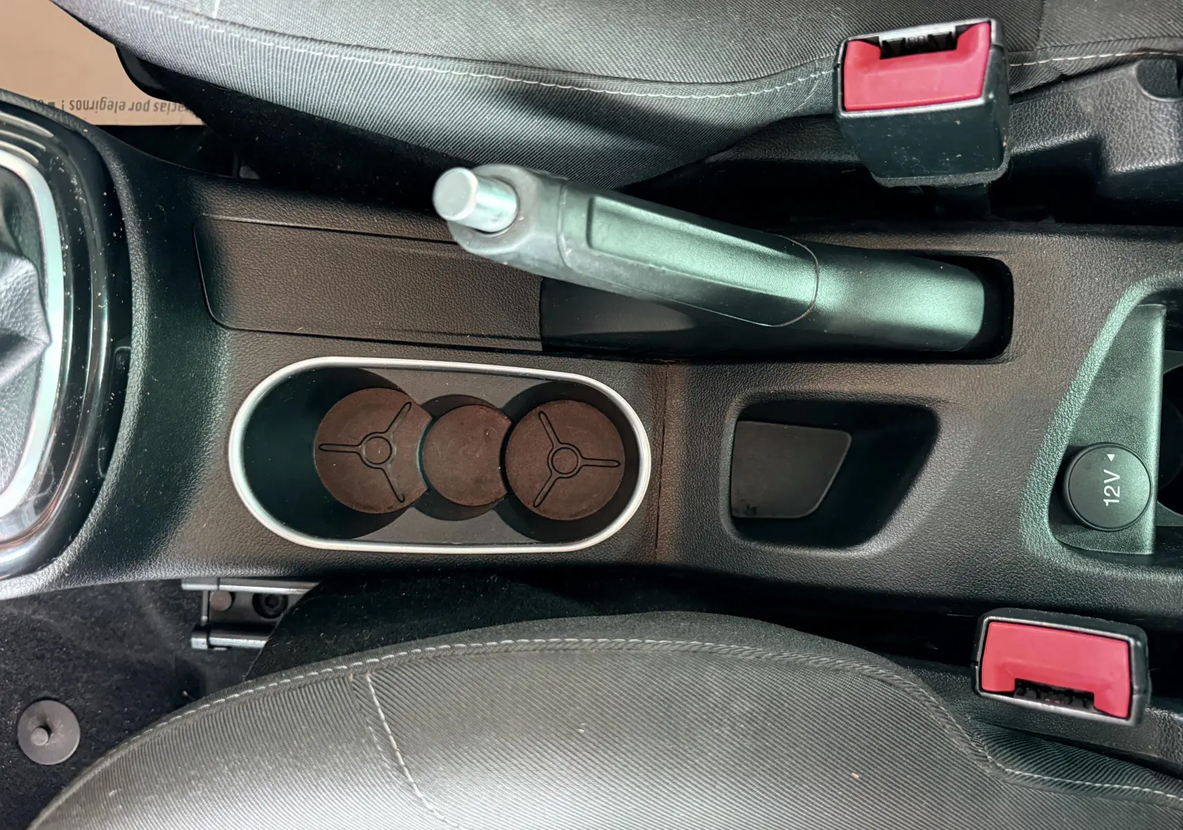 Vue plongeante sur la console centrale noire du Ford B-MAX avec frein à main, porte-gobelets et prises 12V visibles