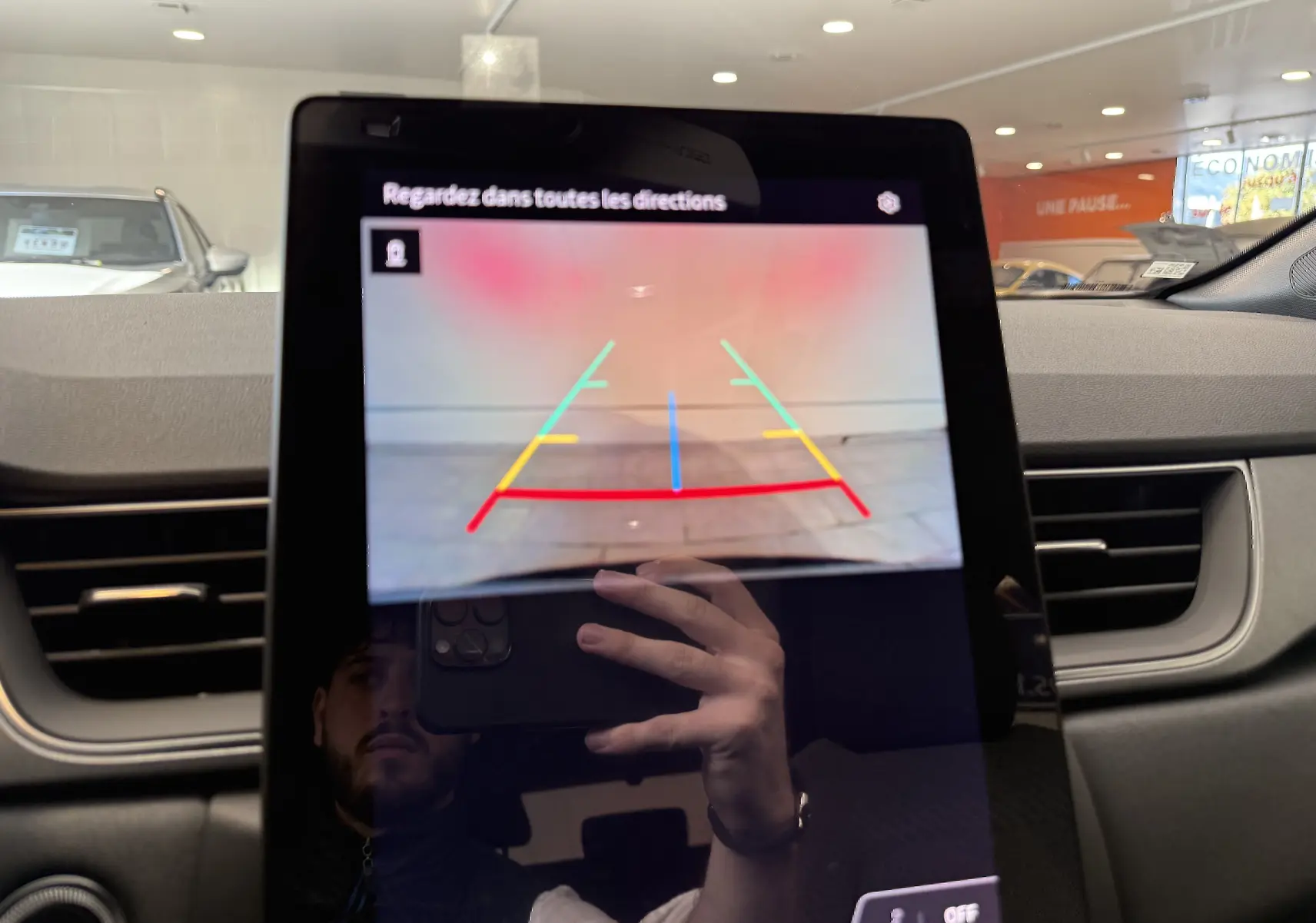 Affichage de la caméra de recul sur l'écran central du tableau de bord d'un Renault Captur gris Cassiopée métal.