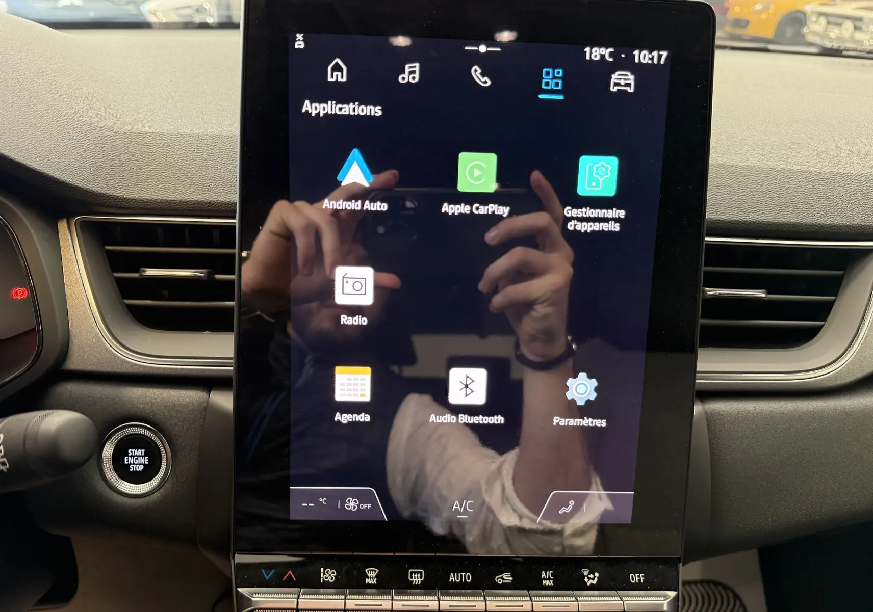 Écran tactile central du tableau de bord du Renault Captur 2025, avec commandes climatisation et bouton start/stop visibles.