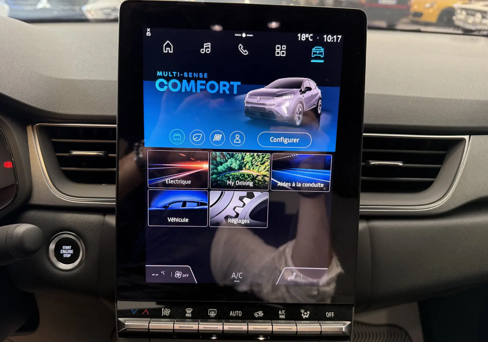 Écran tactile central du tableau de bord du Renault Captur 2025, affichant le mode de conduite Comfort, entouré de commandes climatisation.