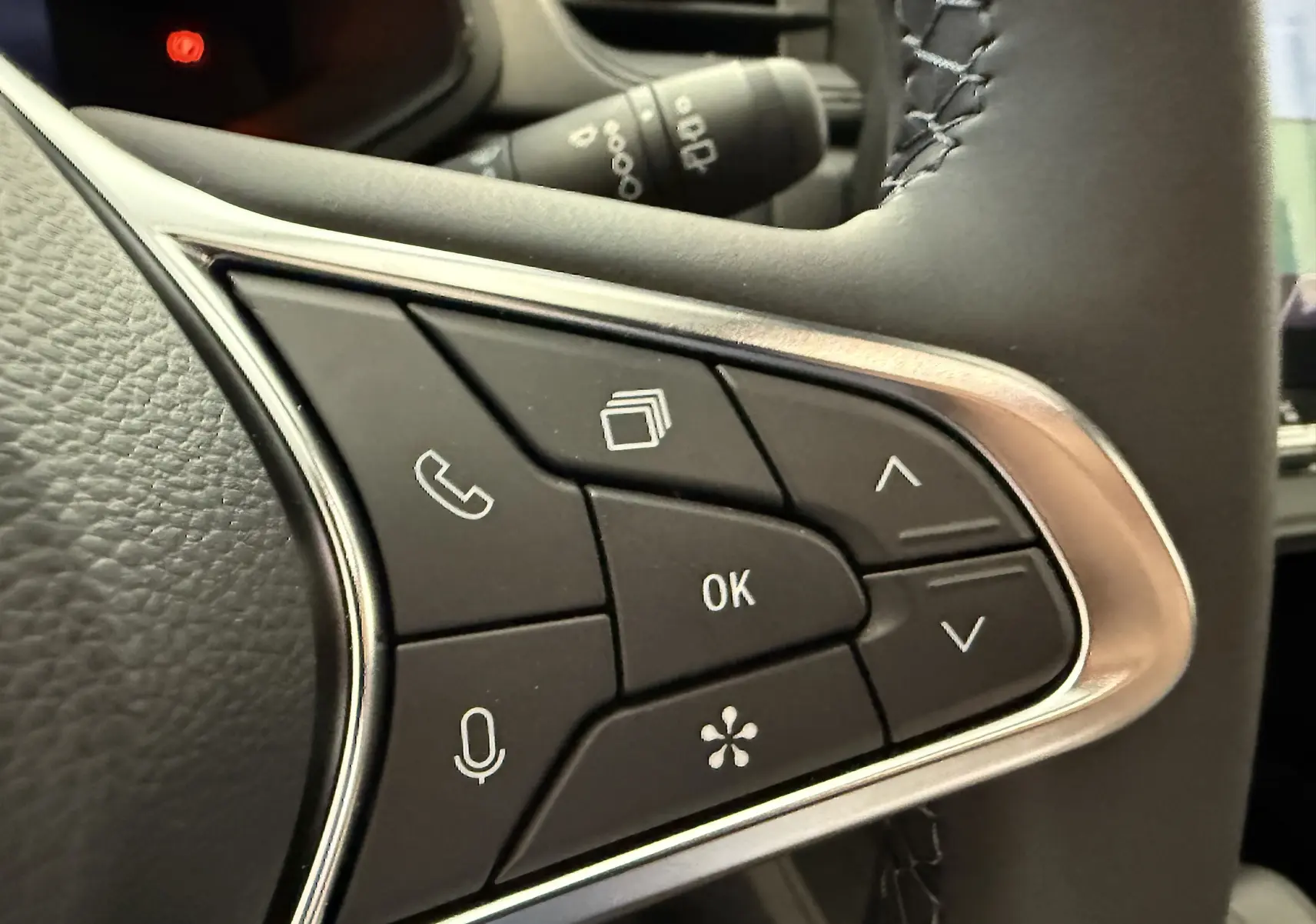 Gros plan sur les commandes multifonctions au volant du Renault Captur 2025, finition gris cassiopée métal.