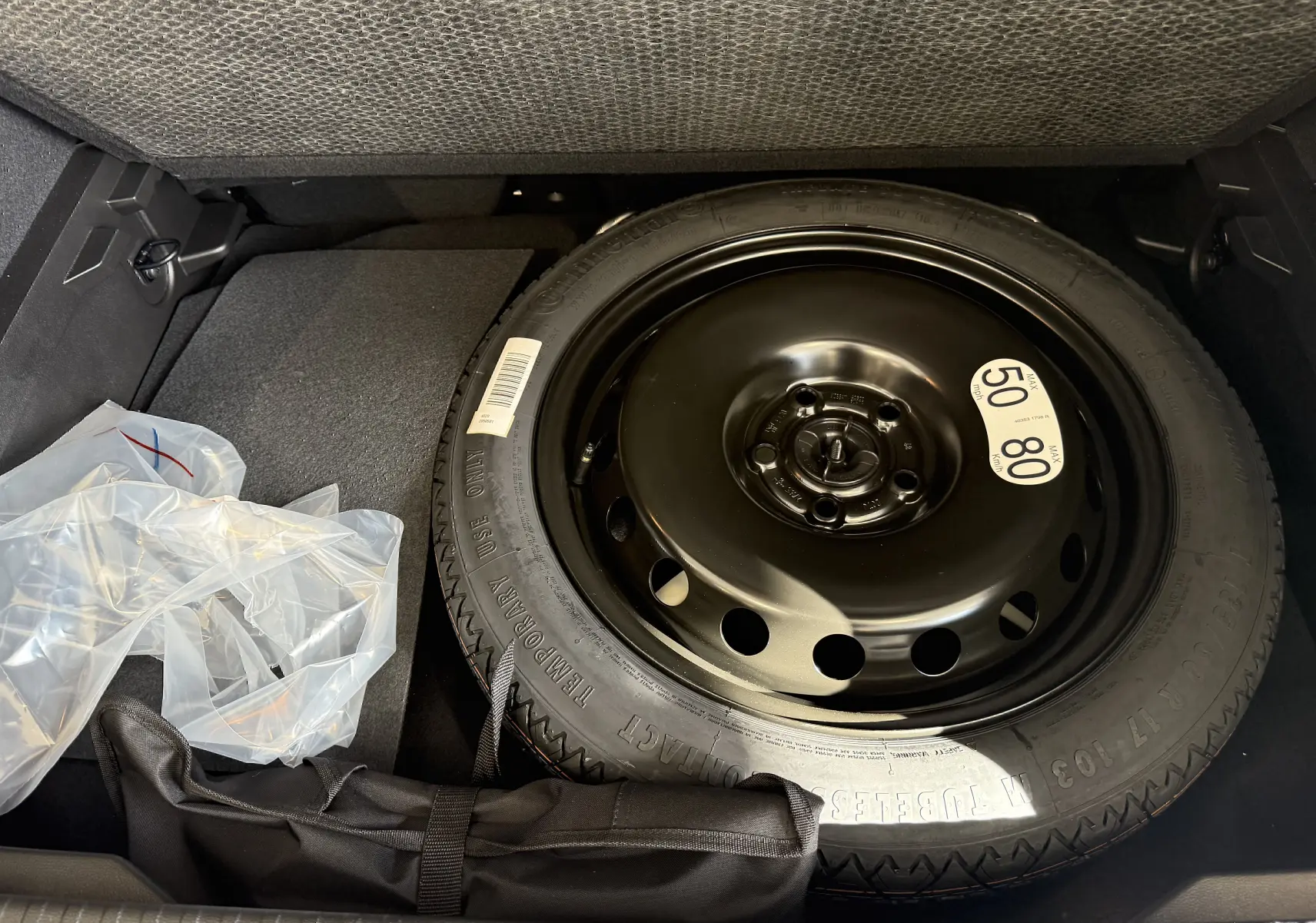 Vue rapprochée de la roue de secours noire dans le coffre du Renault Captur gris Cassiopée Métal 2025.