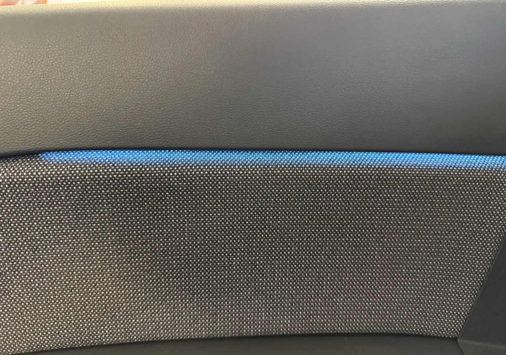 Détail de la garniture intérieure grise avec surpiqûres bleues du Renault Captur 2025 hybride.