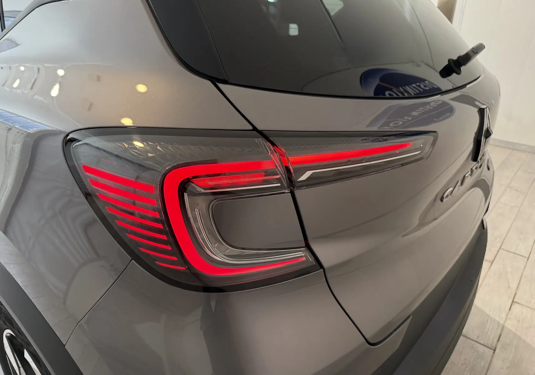 Vue arrière côté gauche du Renault Captur gris Cassiopée Métal, mettant en valeur le feu arrière LED au design moderne.