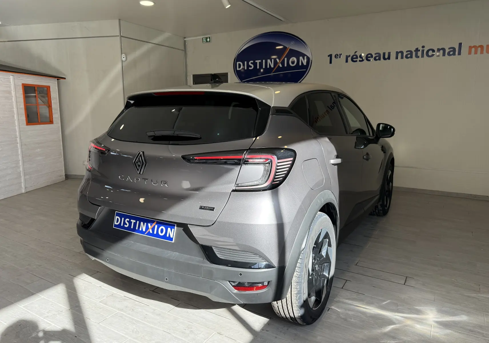 Vue 3/4 arrière droite du Renault Captur gris Cassiopée métal avec toit gris, feux arrière LED et jantes noires.