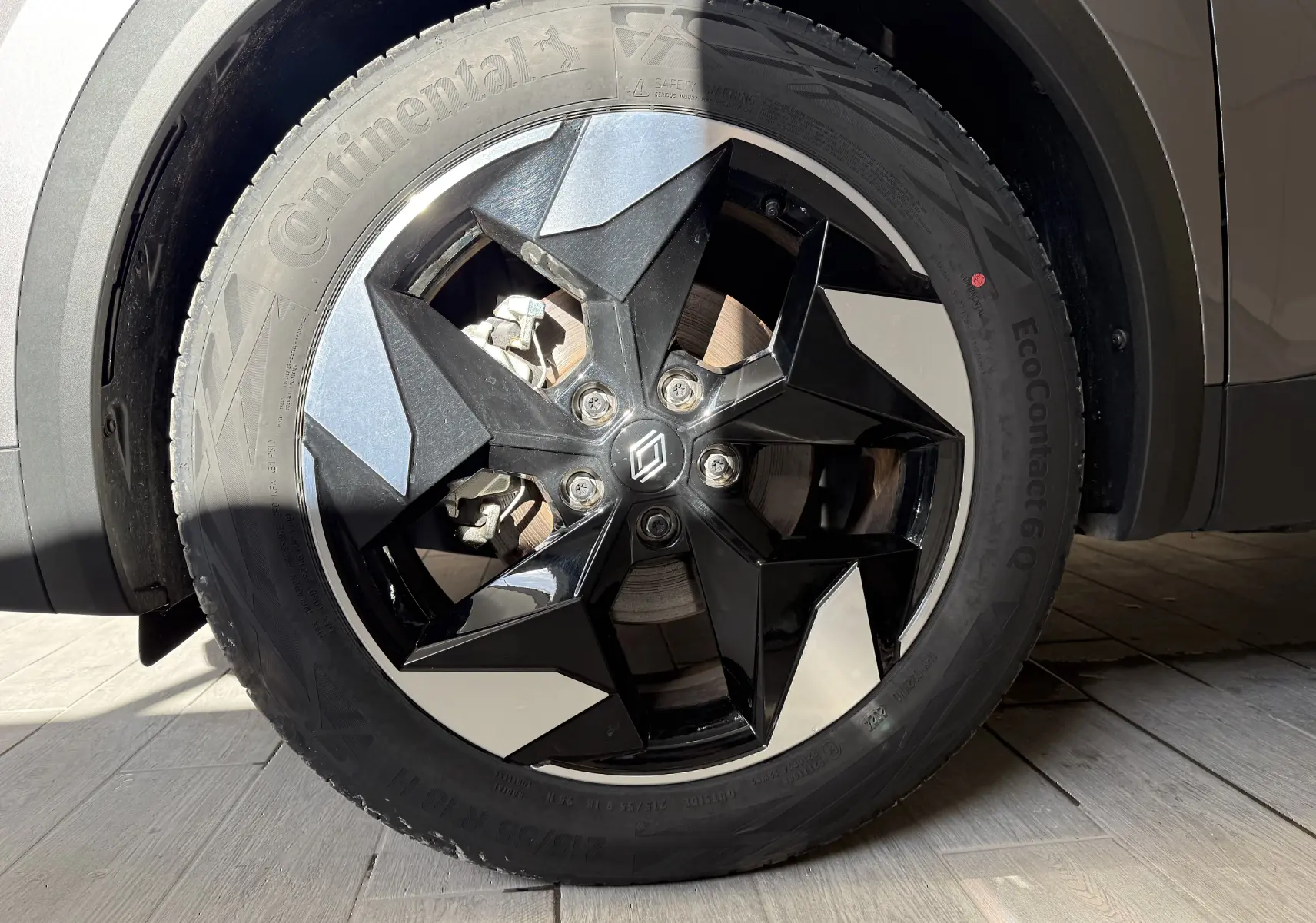 Gros plan sur la jante avant droite du Renault Captur gris Cassiopée, avec un design noir et argenté distinctif.