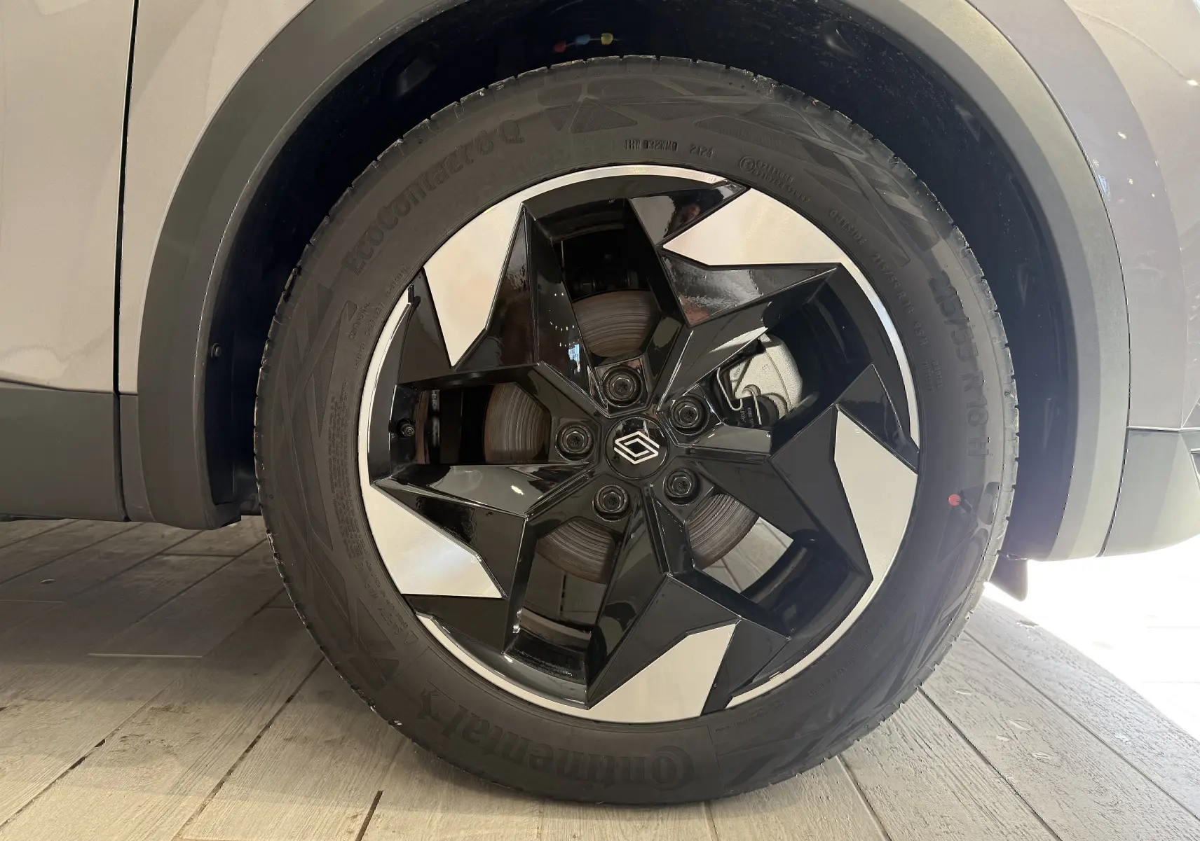Gros plan sur la roue avant droite du Renault Captur gris Cassiopée, jante alliage noire et argentée au design géométrique.