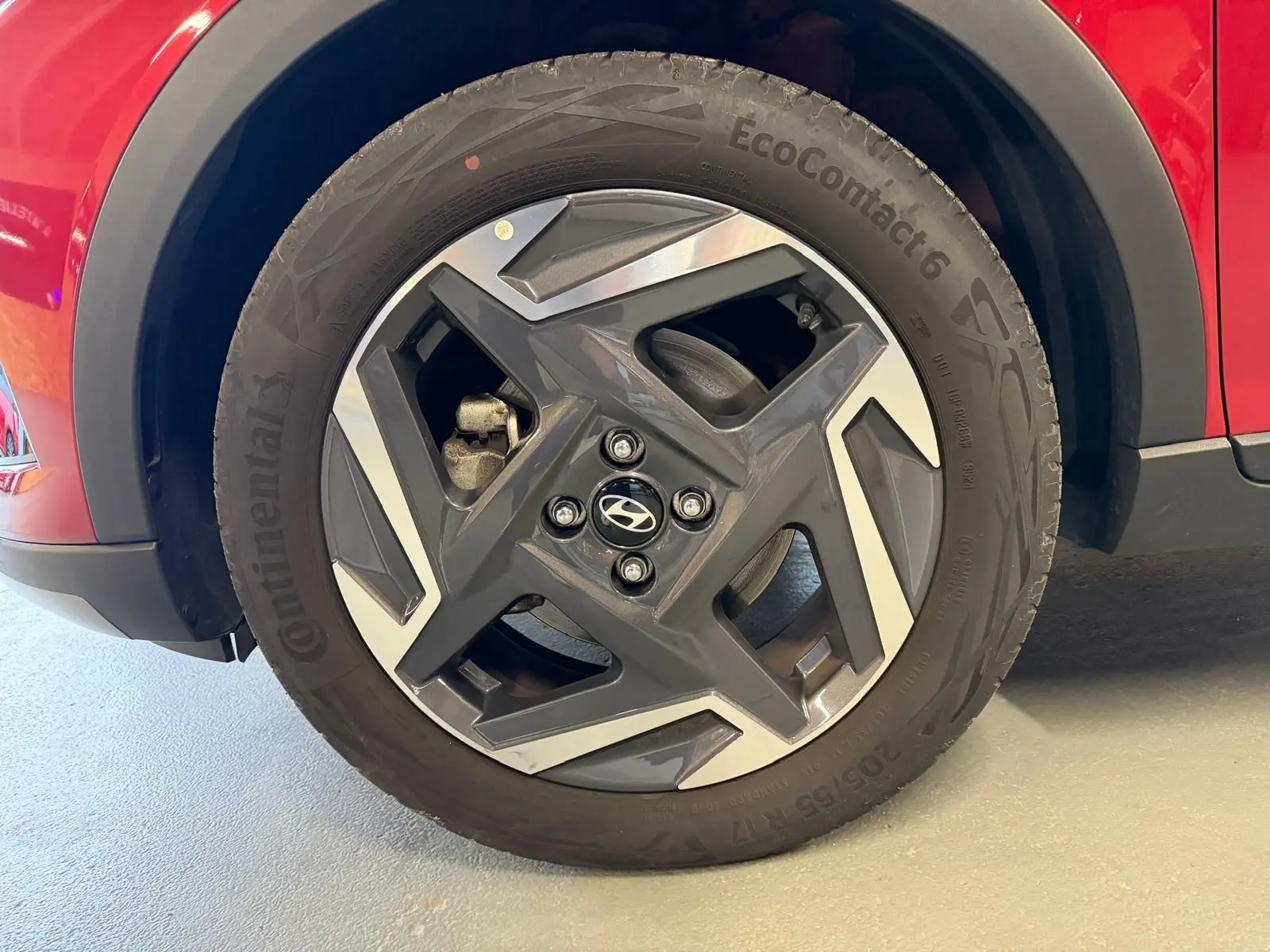 Gros plan sur la jante alu 17'' noire et argentée du côté avant gauche d'une Hyundai Bayon rouge.