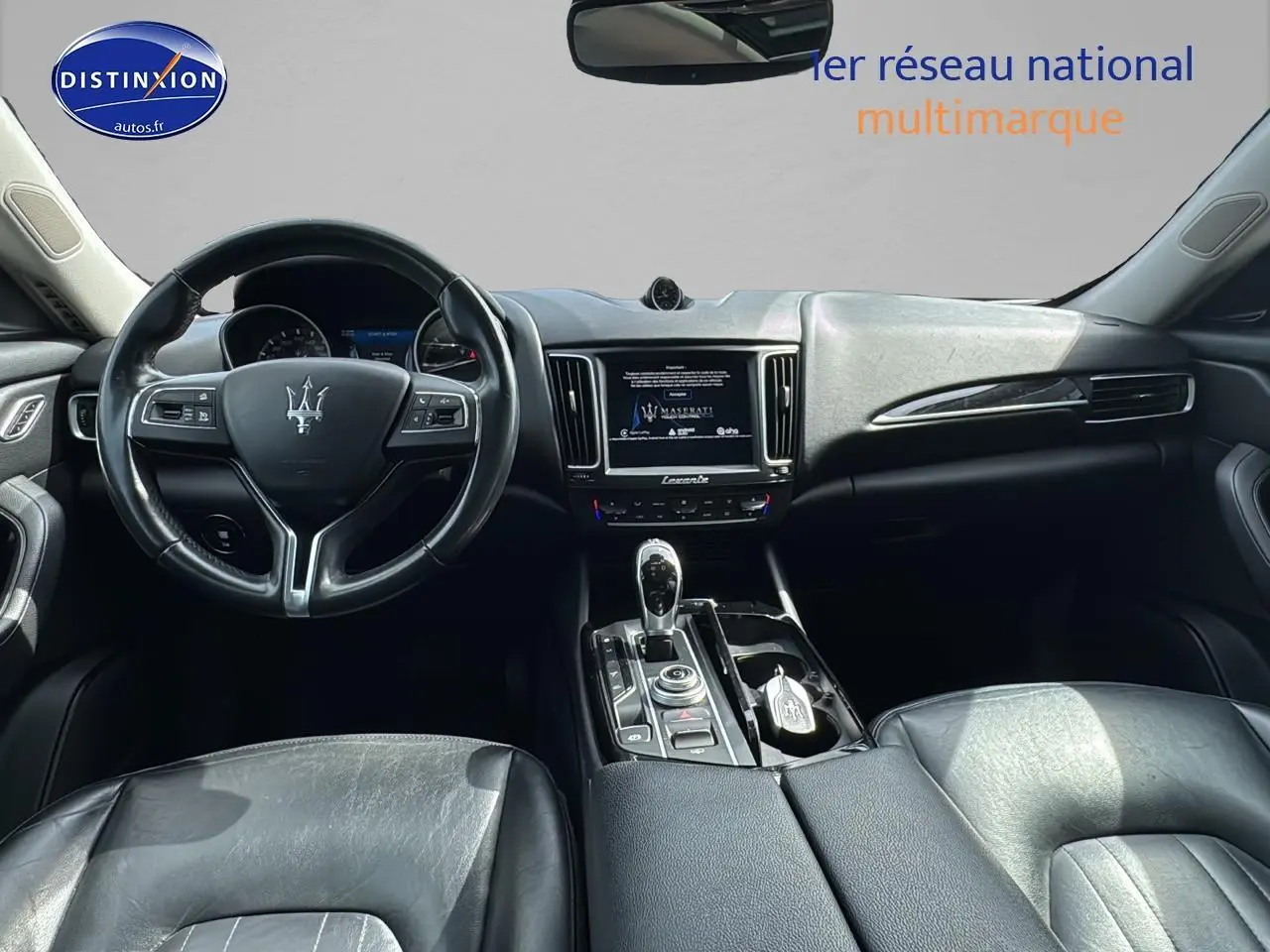 Intérieur noir du Maserati Levante 2017 vu de face, avec volant cuir et console centrale équipée d'un écran tactile.