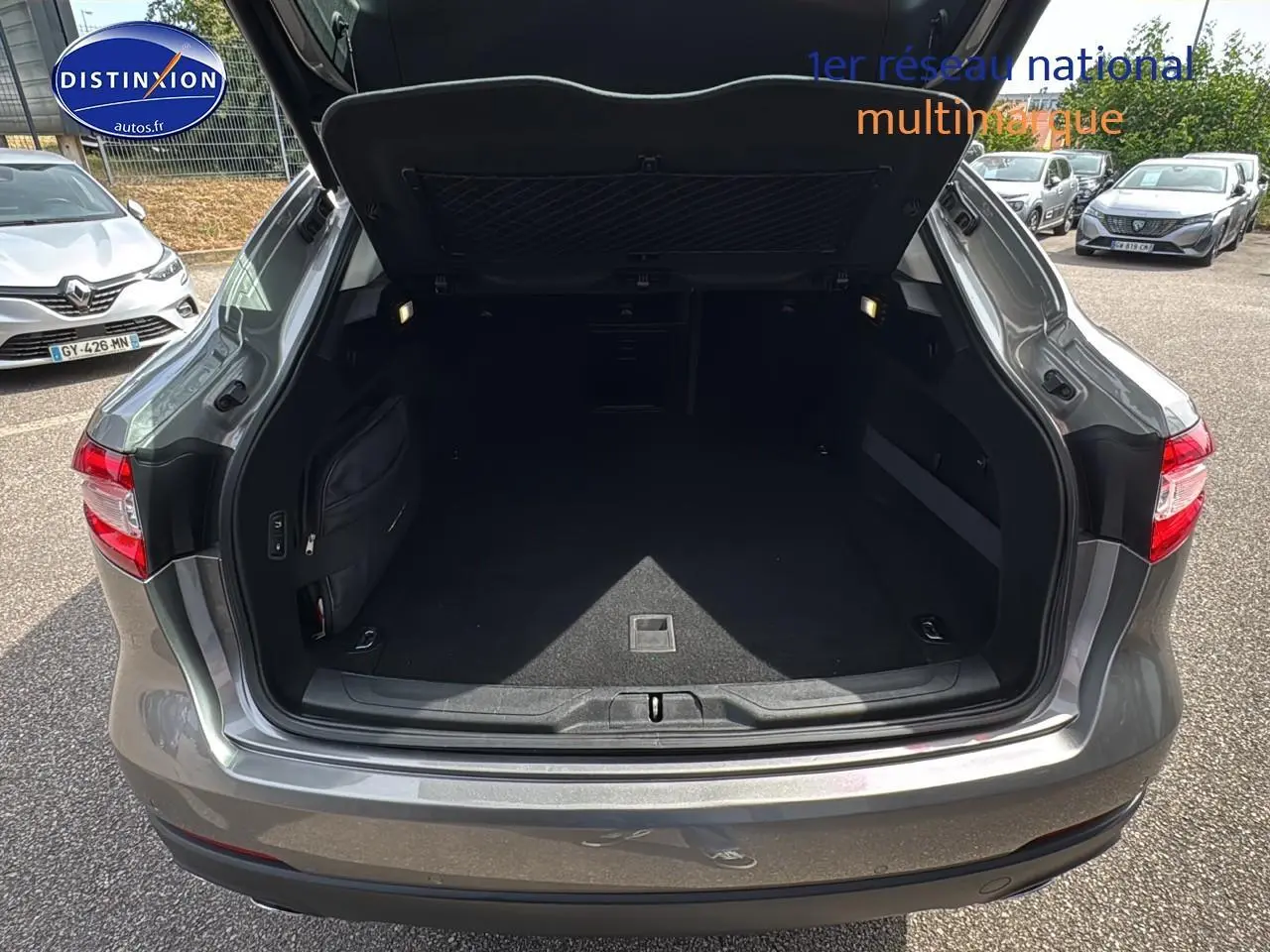 Coffre ouvert vu de l'arrière d'un Maserati Levante gris 3.0 V6 275 Granlusso, avec feux arrière visibles.
