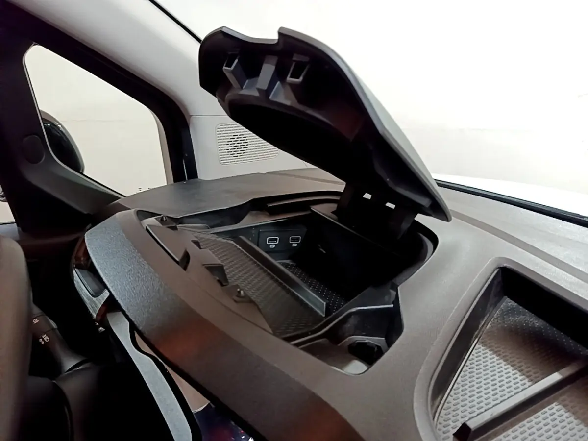 Vue intérieure rapprochée du coffre de rangement ouvert sur le tableau de bord du Renault Kangoo blanc 2022.