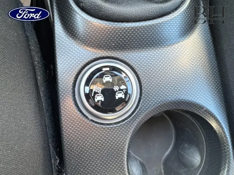 Bouton de sélection de mode de conduite sur console centrale noire, intérieur d'une Fiat 500X argentée.