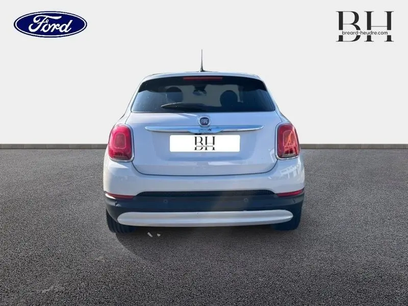 Vue arrière d'un FIAT 500X argenté avec lunette arrière surteintée et feux arrière caractéristiques visibles.