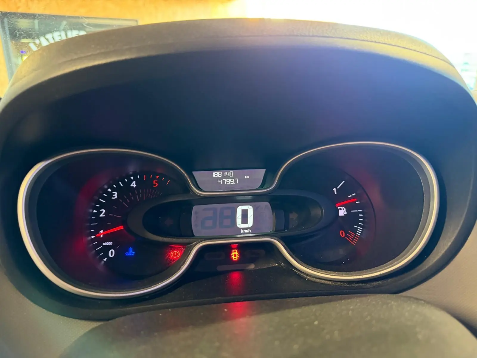 Vue rapprochée du tableau de bord digital du Renault Trafic blanc, affichant 0 km/h et jauge de carburant visible.