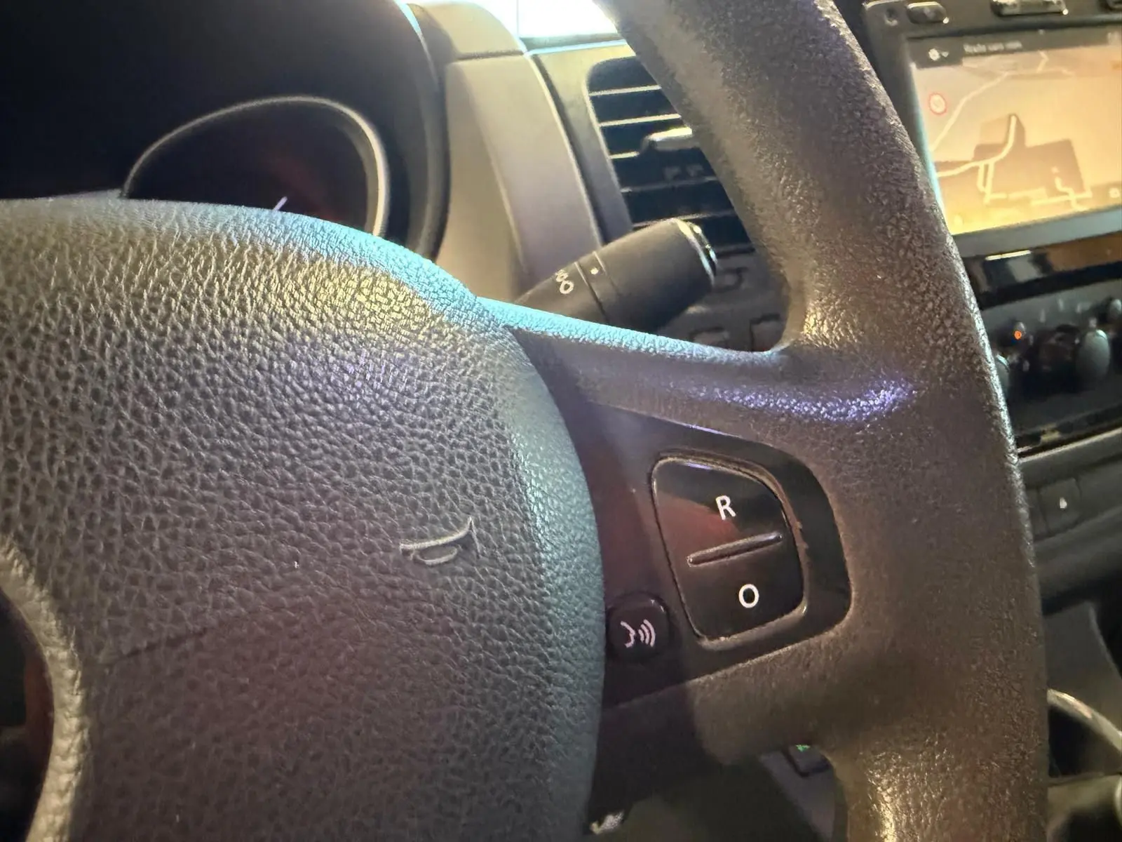 Gros plan sur le volant noir du Renault Trafic Fourgon 2017 avec commandes intégrées et écran GPS en arrière-plan.