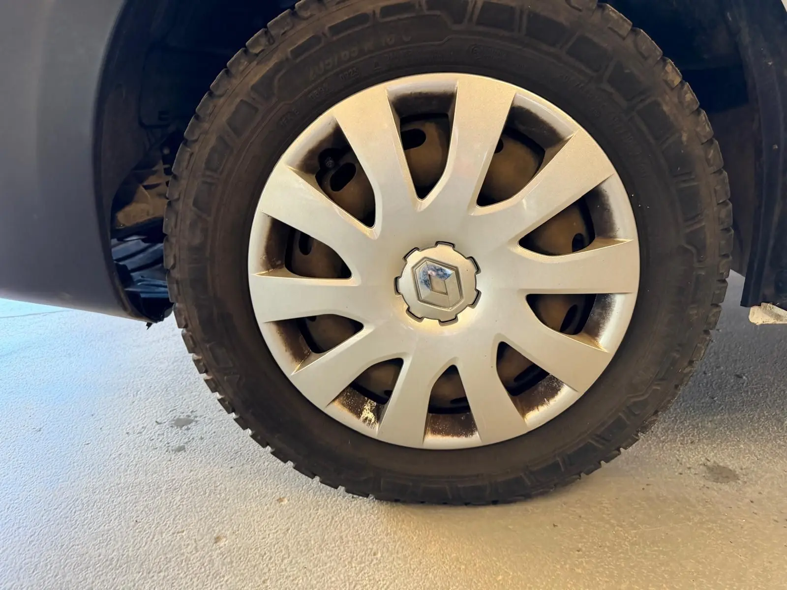 Gros plan sur la roue avant gauche du Renault Trafic Fourgon blanc, avec enjoliveur argenté et logo Renault central.