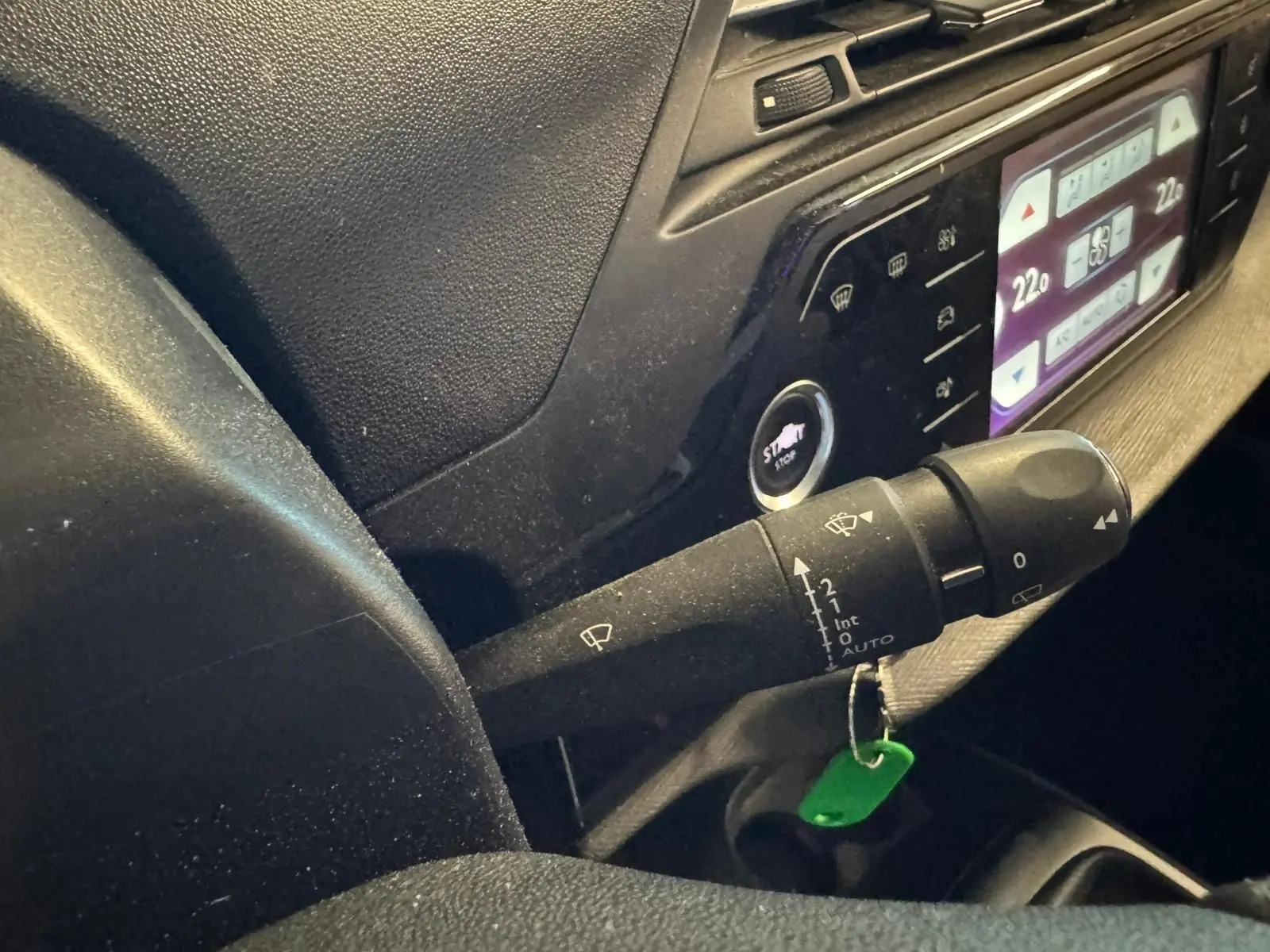 Gros plan intérieur sur la commande d’essuie-glace et le tableau de bord numérique d’une Citroën C4 Picasso 2016.