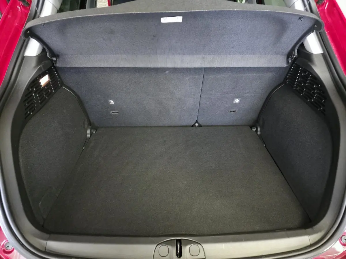 Coffre ouvert vu de dessus du Fiat 500X rouge, montrant un espace de chargement propre et vide.