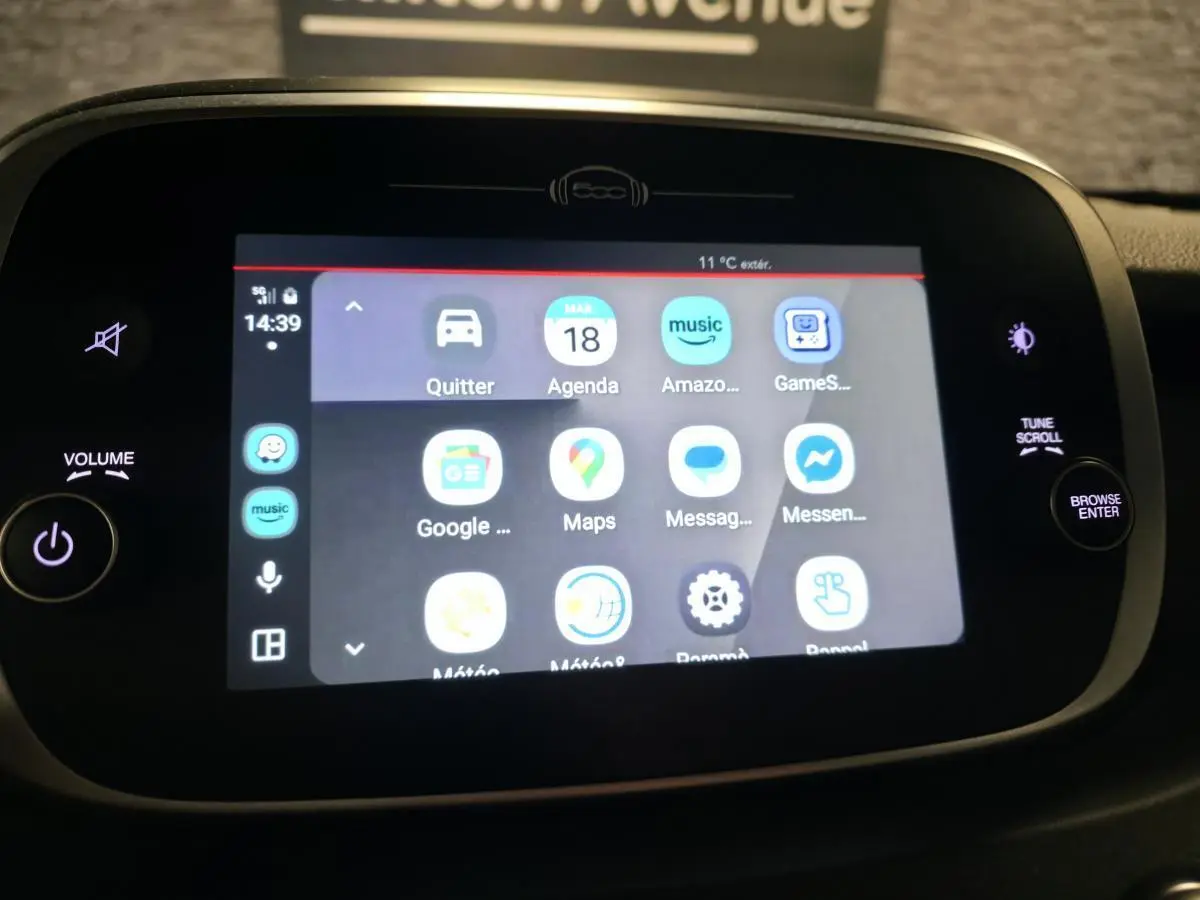 Écran tactile central de la Fiat 500X 2024 affichant les applications multimédia avec commandes autour en noir mat.