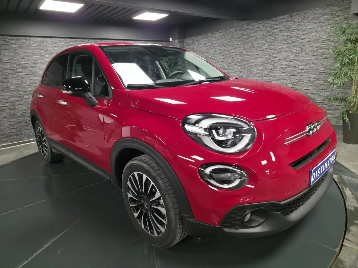 Fiat 500X rouge Passione en 3/4 avant droit, avec jantes alliage 17'' et coques de rétroviseurs noires.