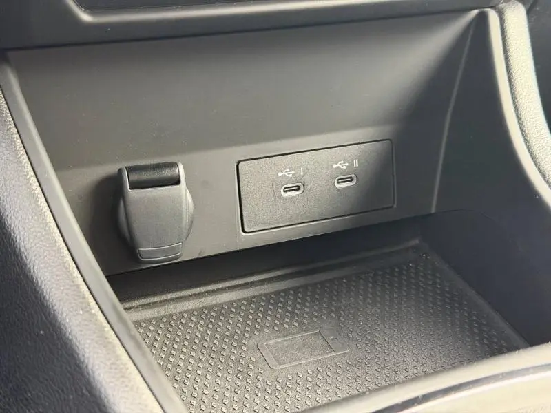 Gros plan sur la console centrale du Renault Captur 2025 montrant deux ports USB-C et une prise 12V, surface antidérapante noire.