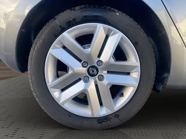 Gros plan sur la roue avant droite de la Renault Clio gris foncé, mettant en valeur la jante alliage au design moderne.
